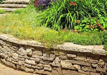 Un jardín mediterráneo con piedras de muro